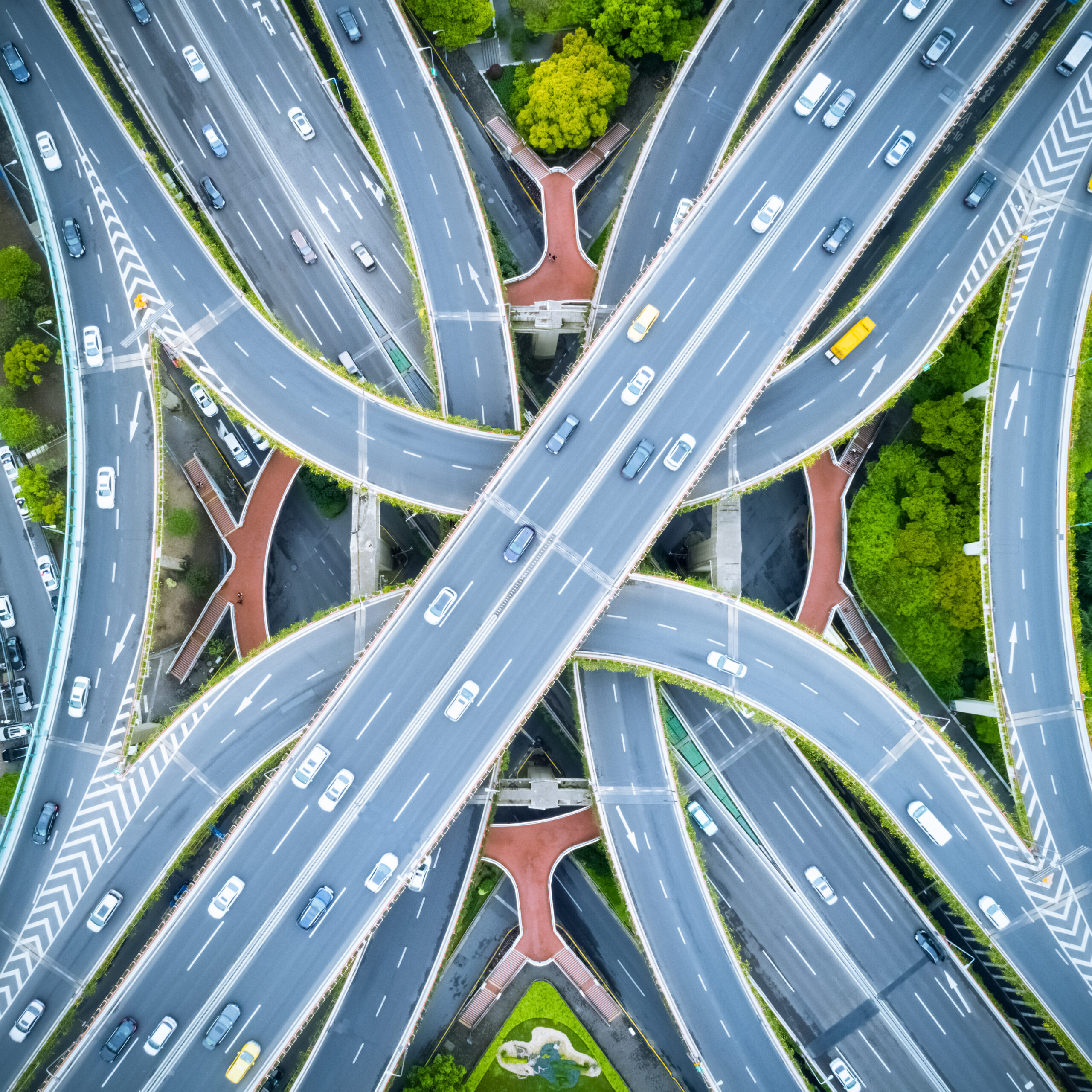Aerial view of a complex multi-level highway interchange with looping ramps and green medians.