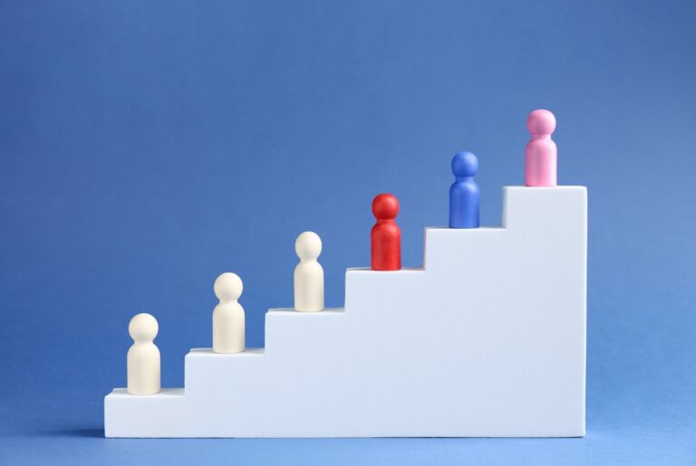 Six colorful peg figures ascending a white staircase against a blue background, symbolizing growth and progression.